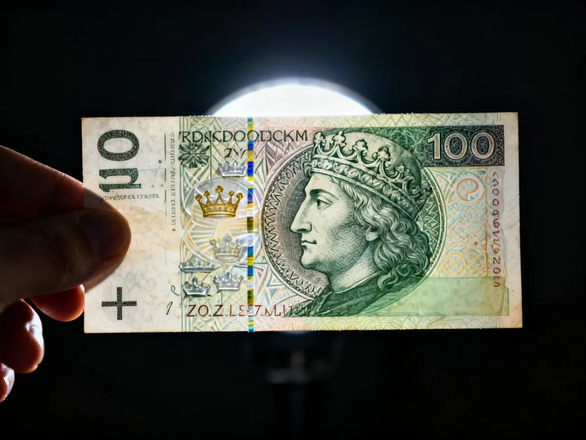 Banknot 100 zł oglądany pod światło z widocznymi zabezpieczeniami